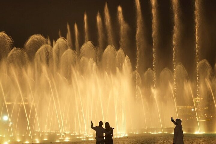 Experience the magic of the Dubai Fountain as water dances to music illuminating the night with stunning visual displays and creating unforgettable memories amidst iconic cityscapes.